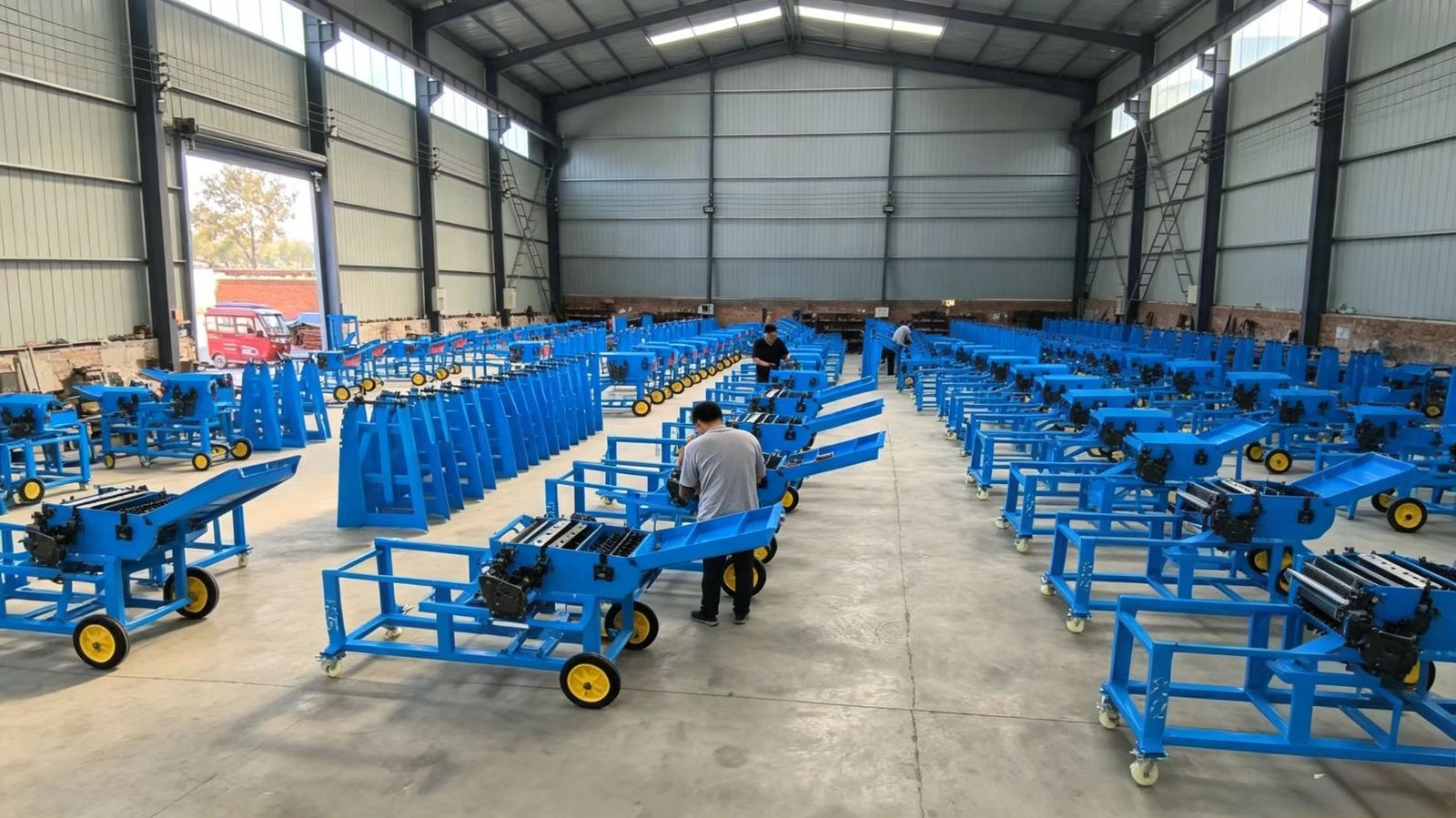 Rows of Sunto chaff cutter machine frames and feeding hoppers in the factory workshop